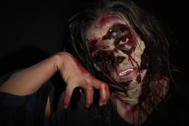 Karanlık arka planda korkunç bir zombi, yakın plan. Cadılar Bayramı canavarı