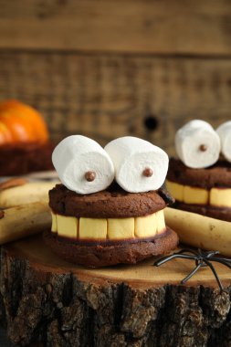 Enfes tatlılar, kütük üzerinde canavarlar olarak süslenmiş, yakın plan. Cadılar Bayramı hediyesi