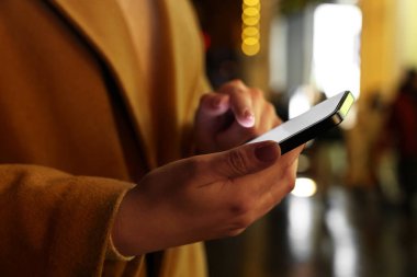 Şehir sokağında akıllı telefon kullanan kadın, yakın plan.