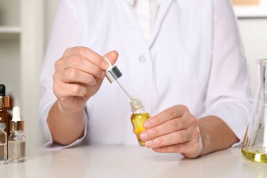 Dermatolog beyaz masada kozmetik yağı geliştiriyor.