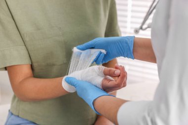 Hastanın elini saran doktor içeride yanmış, yakın plan.