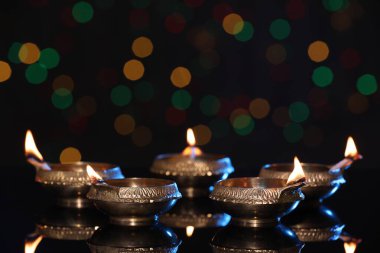Karanlık arka planda bulanık ışıklarla aydınlatılmış diyadalar, metin için boşluk. Diwali lambaları
