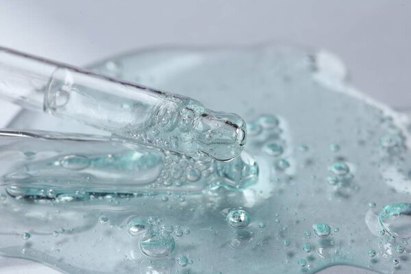 Pipettes with cosmetic serum on white background, closeup. Space for text
