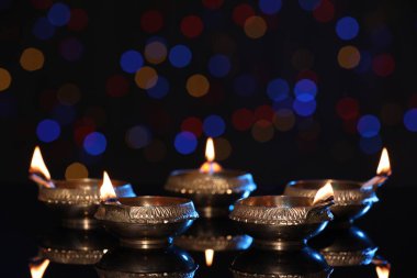 Karanlık arka planda bulanık ışıklarla aydınlatılmış diyadalar, metin için boşluk. Diwali lambaları