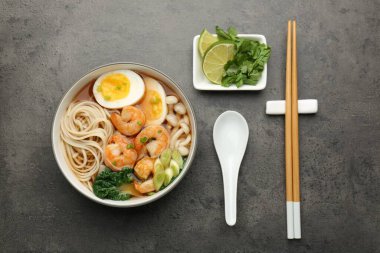 Gri masada servis edilen karidesli ve yumurtalı ramen. Erişte çorbası.