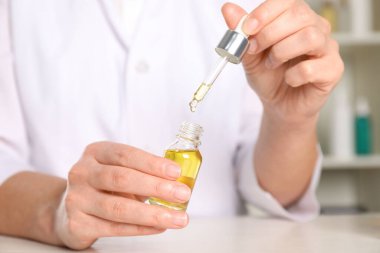 Dermatolog beyaz masada kozmetik yağı geliştiriyor.