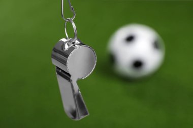 Futbol hakem ekipmanı. Bulanık yeşil arkaplanda metal ıslık, metin için boşluk ile yakın plan