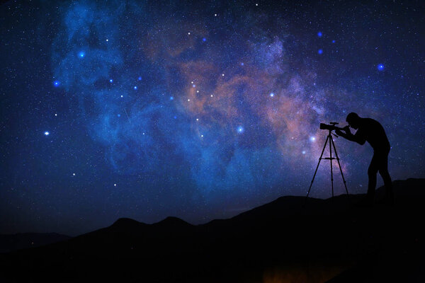 Astronomer looking at starry sky through telescope outdoors. Space for text