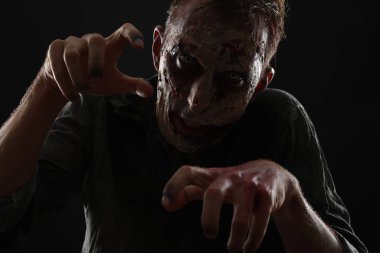 Karanlık arka planda korkunç bir zombi. Cadılar Bayramı canavarı