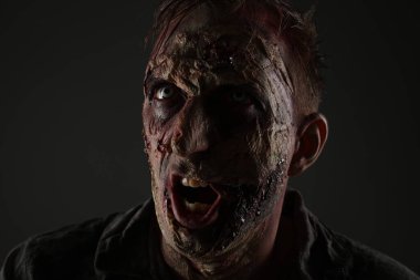 Karanlık arka planda korkunç bir zombi, yakın plan. Cadılar Bayramı canavarı