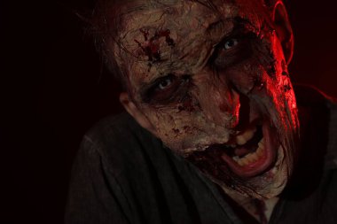 Karanlık arka planda korkunç bir zombi, yakın plan. Cadılar Bayramı canavarı