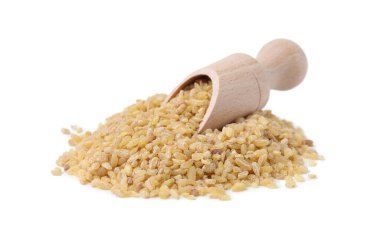 Beyaz üzerinde çiğ bulgur bulunan ahşap kepçe.