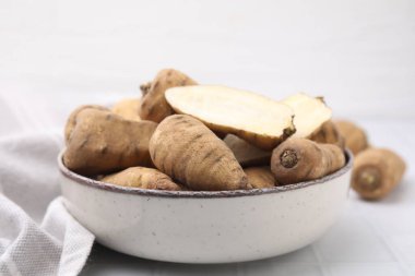 Şalgam tüm ve kesme yumrusu kökleri beyaz karo masa üzerinde kasede, yakın çekim