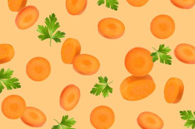 Taze havuç dilimleri ve açık turuncu arka plana düşen yeşil maydanoz.