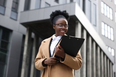 Dışarıda panosu olan mutlu bir kadın. Avukat, iş kadını, muhasebeci ya da müdür.