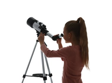 Küçük kız beyaz arka planda teleskopla yıldızlara bakıyor.