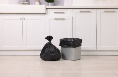 Mutfakta plastik çöp torbası ve çöp kutusu var.
