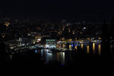 BÖLÜM, CROATIA - 08 Ekim 2023: Geceleyin liman ve binalarla aydınlatılmış şehrin güzel manzarası