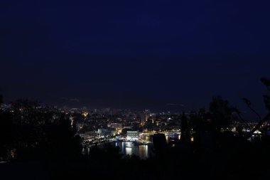 BÖLÜM, CROATIA - 08 Ekim 2023: Geceleyin liman ve binalarla aydınlatılmış şehrin güzel manzarası