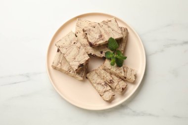 Lezzetli çikolata helva parçaları ve beyaz mermer masa üzerinde nane şekeri.