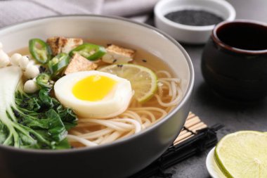 Gri masada bir kase vejetaryen ramen, yakın plan.