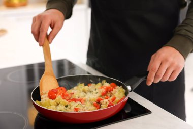 Kapalı mekanda yemek pişiren adam, yakın plan.