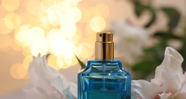 香水とベージュの背景に対する美しいリリーの花のボトル ぼやけたライト クローズアップ — ストック写真