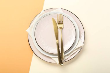 Seramik tabaklar, çatal bıçak takımı ve peçete.