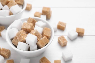 Farklı şeker küpleri beyaz masada, yakın plan.