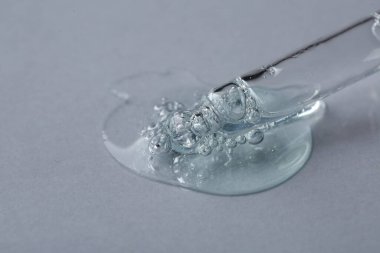 Beyaz arka planda kozmetik serumu olan boru hattı, makro görünüm