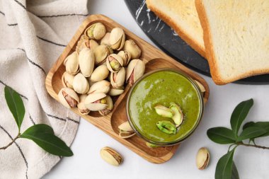 Beyaz masada servis edilen fıstıklı krema ve fındıklar düzdü.