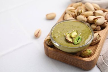 Fıstıklı krema kasede, fındıklı beyaz fayanslı masa, yakın plan. Metin için boşluk