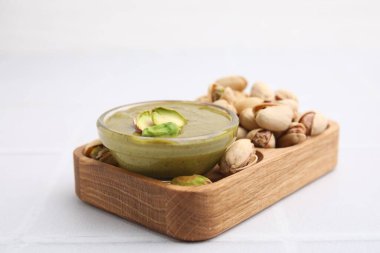 Fıstıklı krema kasede, fındıklı beyaz fayanslı masa, yakın plan.