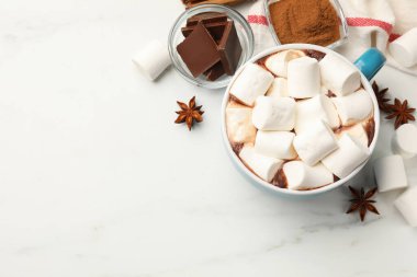 Lezzetli sıcak çikolata, şekerleme ve beyaz mermer masa üzerindeki malzemeler, düz yatak. Metin için boşluk