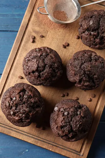 Köstliche Schokoladenmuffins Und Sieb Mit Kakaopulver Auf Blauem Holztisch Draufsicht — Stockfoto