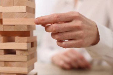 Bulanık arkaplanda Jenga kulesi oynayan kadın, yakın plan