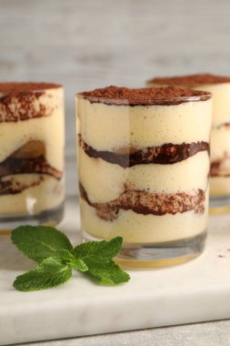 Gözlüklü nefis tiramisu ve nane şekeri masada, yakın plan.