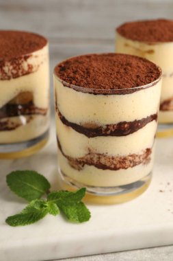 Gözlüklü nefis tiramisu ve nane şekeri masada, yakın plan.