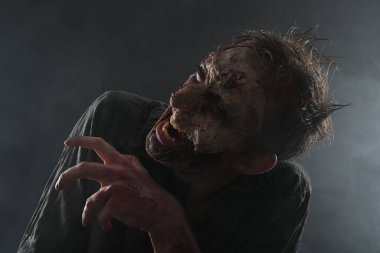 Karanlık arka planda korkunç bir zombi. Cadılar Bayramı canavarı