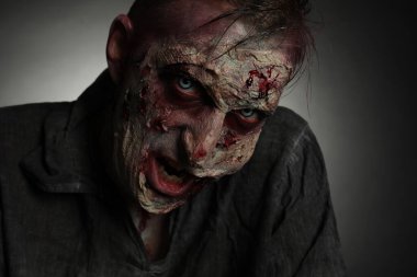 Karanlık arka planda korkunç bir zombi, yakın plan. Cadılar Bayramı canavarı