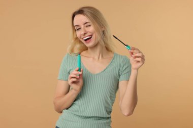 Bej arkaplanda rimel olan güzel bir kadın.