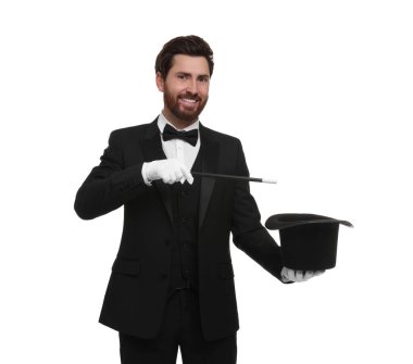 Mutlu sihirbaz beyaz arka planda silindir şapkalı sihirbazlık numarası yapıyor.