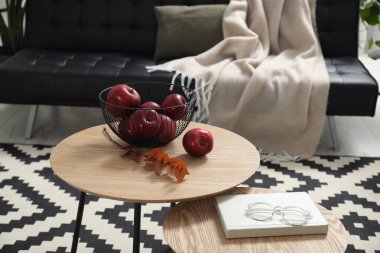 Kırmızı elmalar, kuru okaliptüs dalı, odadaki yuva masaları üzerine kitap ve bardaklar, metin için yer