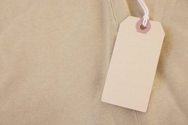 Bej giysili karton etiket, üst manzara. Metin için boşluk