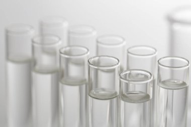 Laboratuvar analizi. Bulanık arkaplanda birçok cam test tüpü, yakın plan