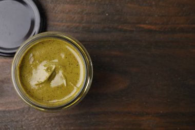 Ahşap masanın üstünde kavanozda fıstıklı krema, üst manzara. Metin için boşluk