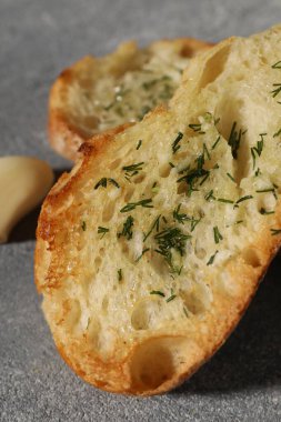 Gri desenli masada sarımsak ve dereotlu baget, yakın plan.