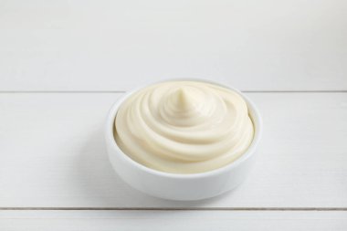 Beyaz ahşap masada kasede taze mayonez sosu.