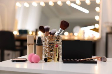Makyaj odasındaki beyaz masada farklı kozmetik ürünleri.