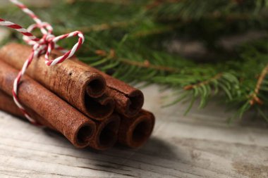 Tarçın çubukları ve köknar dalları ahşap masada, yakın plan